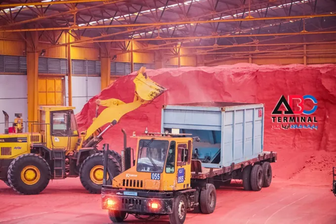 Loader transferring bulk cargo into a truck container